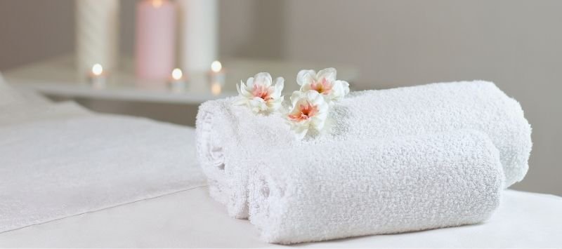 Toallas blancas enrolladas con flores